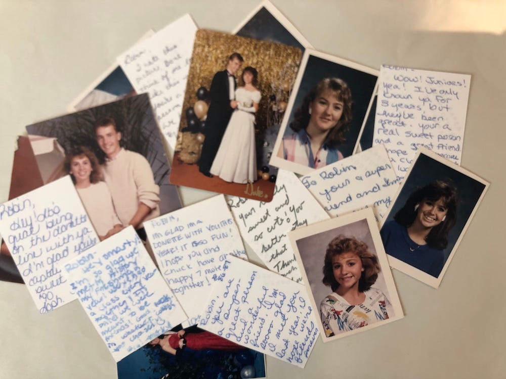 A pile of small photos, some face up, some face down showing handwritten notes.