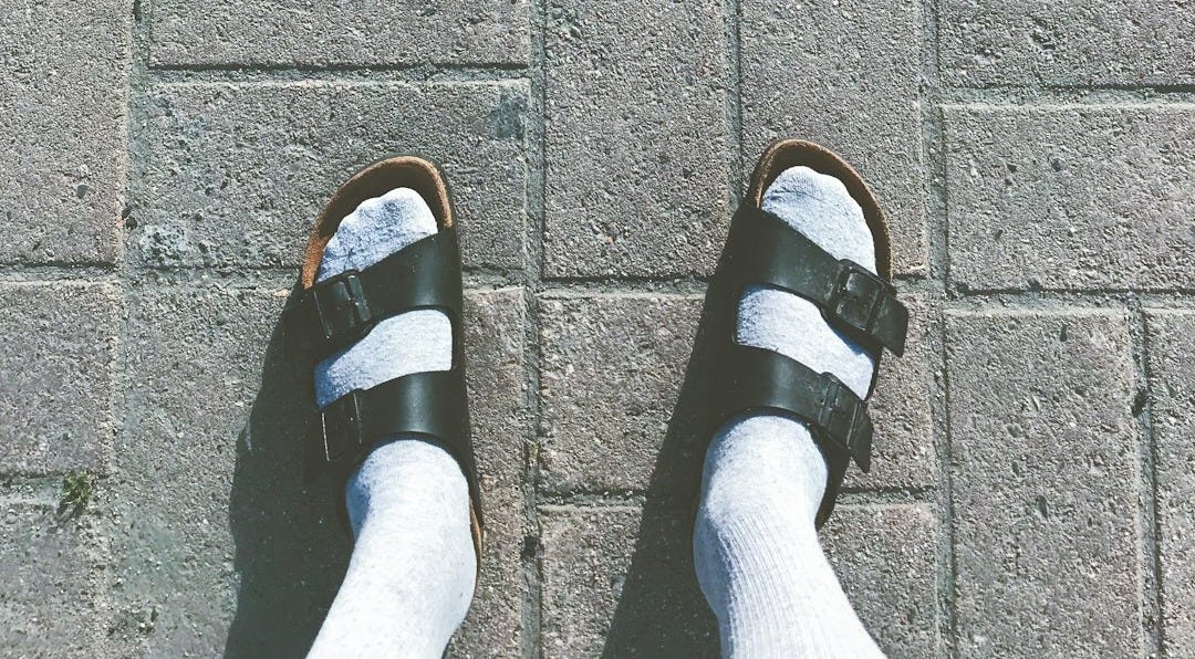 person wearing black and white slide sandals