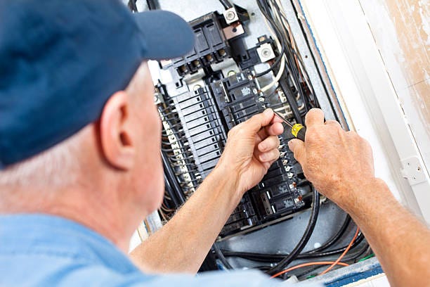 Electrician doing electrical work in breaker box Electrician doing electrical work in breaker box electric panel installation stock pictures, royalty-free photos & images