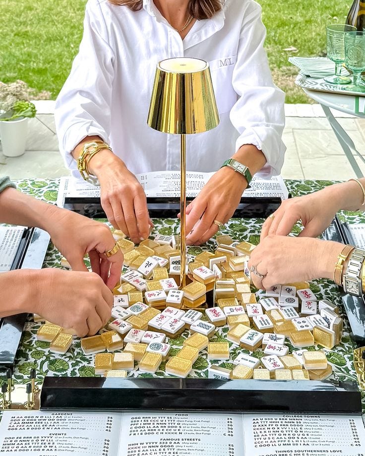 This may contain: three women are playing with small tiles on a table