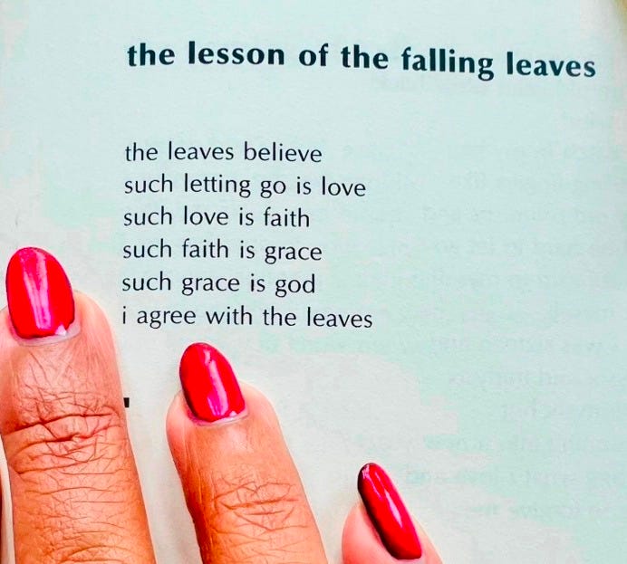 An image taken of the author's fingers on the page as she reads the poem "the lesson of the falling leaves" by Lucille Clifton. The poem's text reads: "the leaves believe/such letting go is love/such love is faith/such faith is grace/such grace is god/i agree with the leaves."