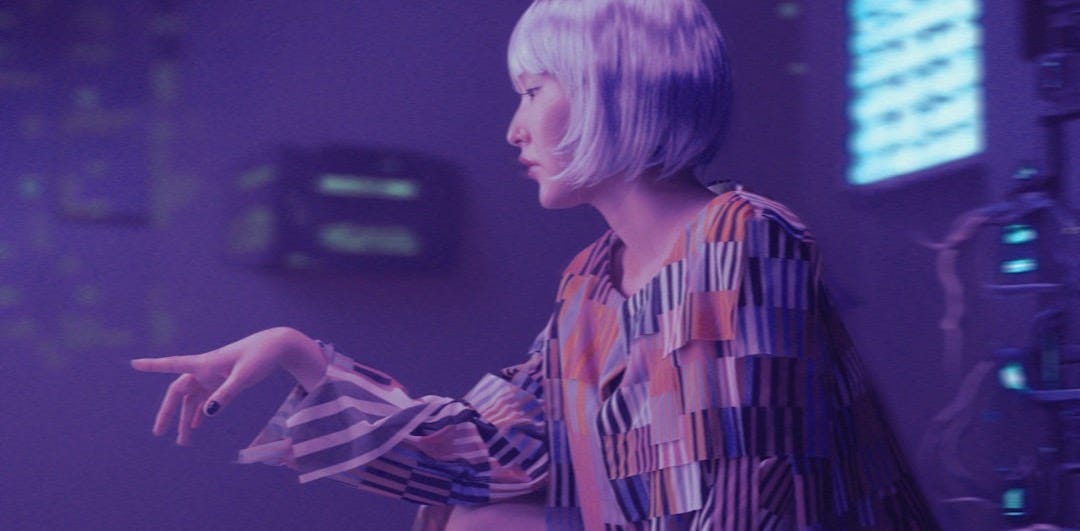 a woman in a colorful dress standing in a room a woman in a colorful dress standing in a room