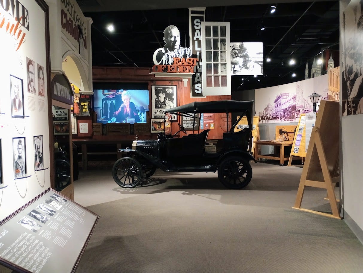 Museum display titled Growing Up East of Eden with movie on screen in imitation freight train car, Model T, images of old Salinas, and entrance to display on Steinbeck's family and childhood Museum display titled Growing Up East of Eden with movie on screen in imitation freight train car, Model T, images of old Salinas, and entrance to display on Steinbeck's family and childhood