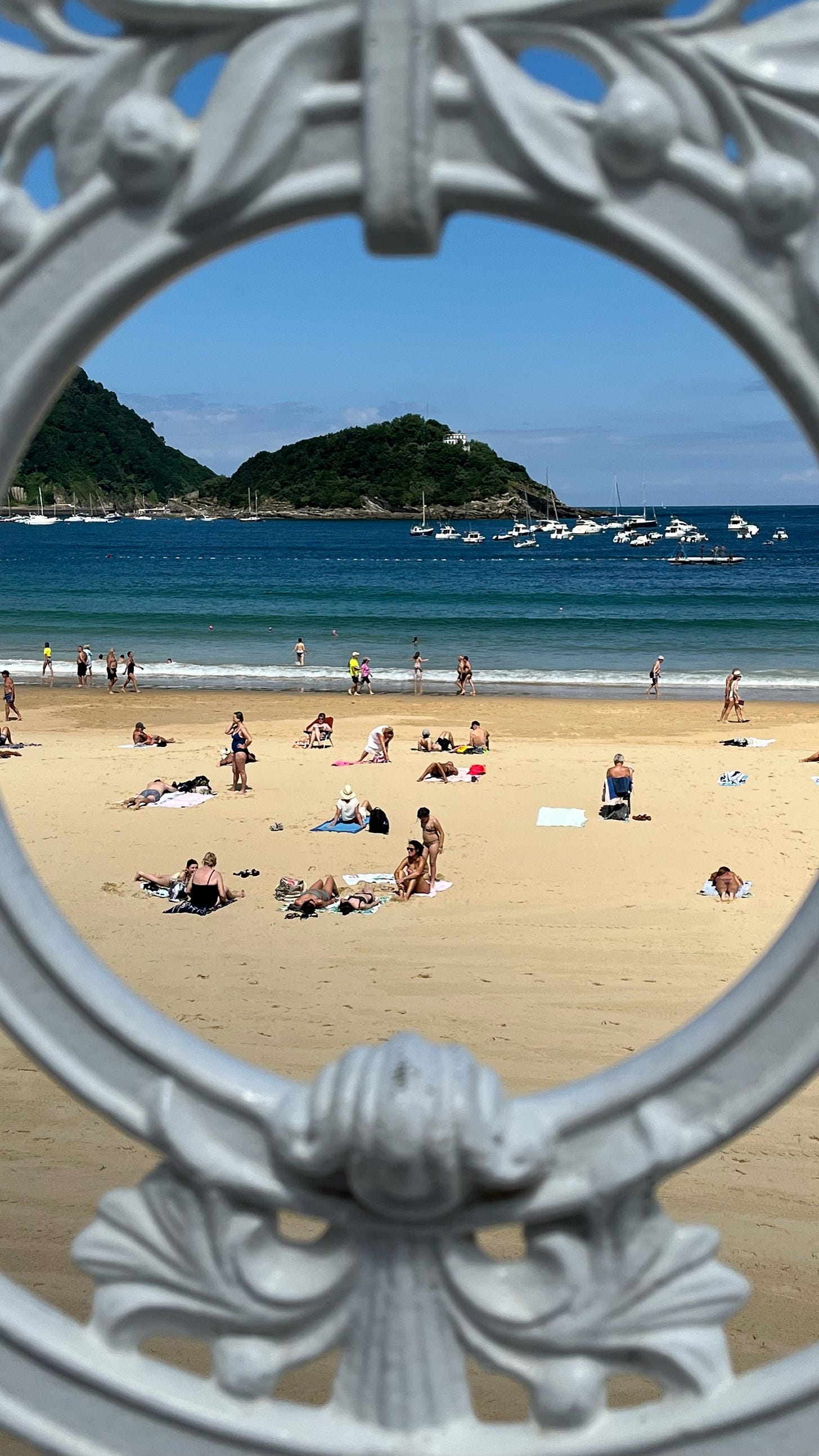 Beach seen through a decorative, circular white gate