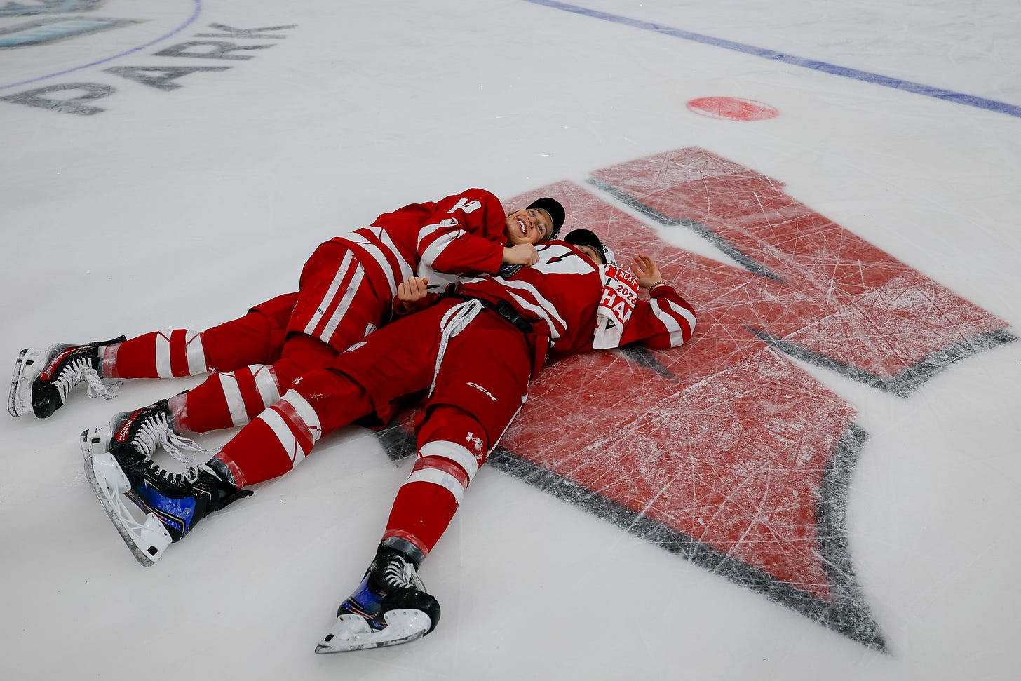 Still dressed in full gear after the game, Wisconsin Badgers seniors Marianne Picard and Kirsten Simms lay side by side together on the ice.