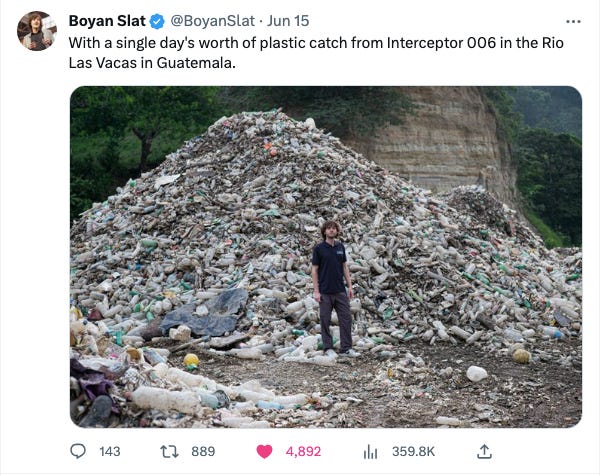 Man standing in front of large pile of plastic. With a single day's worth of plastic catch from Interceptor 006 in the Rio Las Vacas in Guatemala.