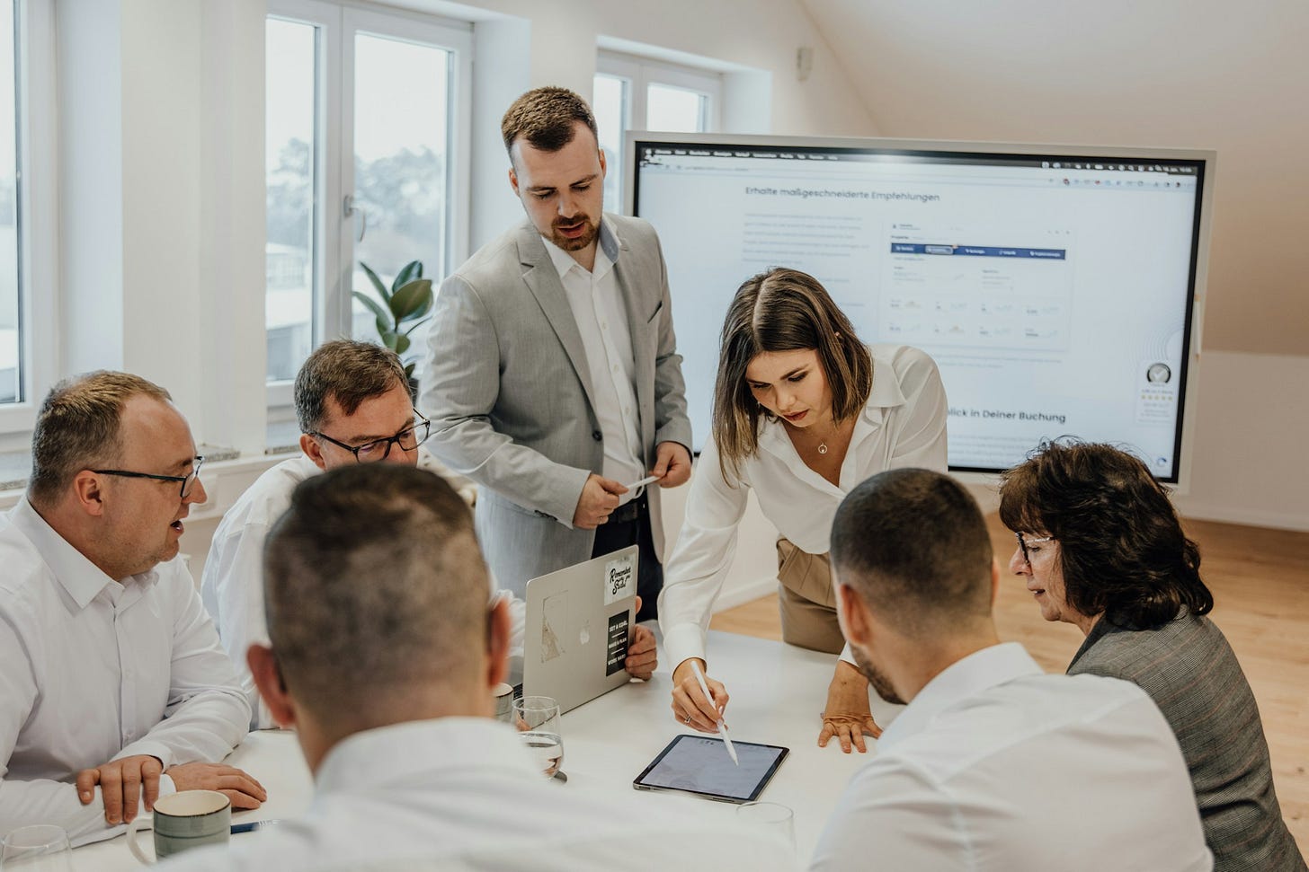 People in discussion around a conference table. Photo by SEO Galaxy on Unsplash