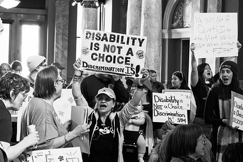 A gallery of black and white photos of a rally in the rotunda of Montana's state capitol. people are holding signs in support of disability rights, there is a podium with legislators speaking, people with a virety of physical disabilities are throughout the crowd.