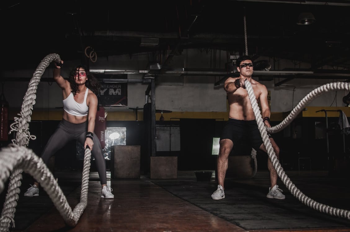 Man And Woman Holding Battle Ropes Man And Woman Holding Battle Ropes