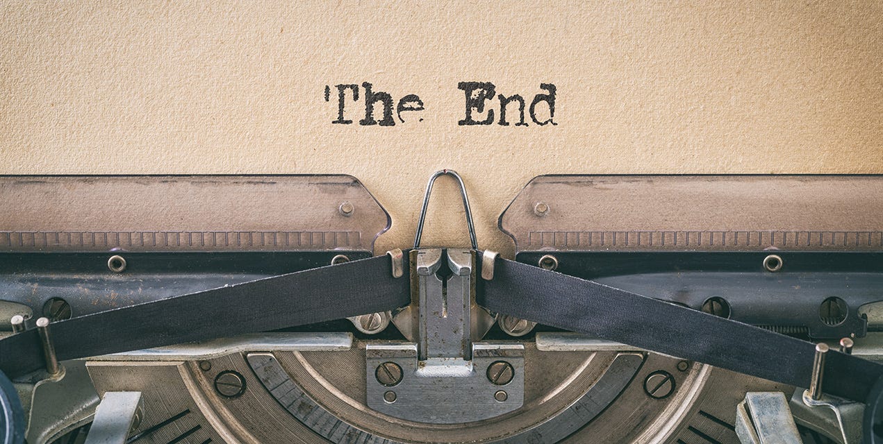 A vintage typewriter with "The End" typed out on a weathered sheet of paper.