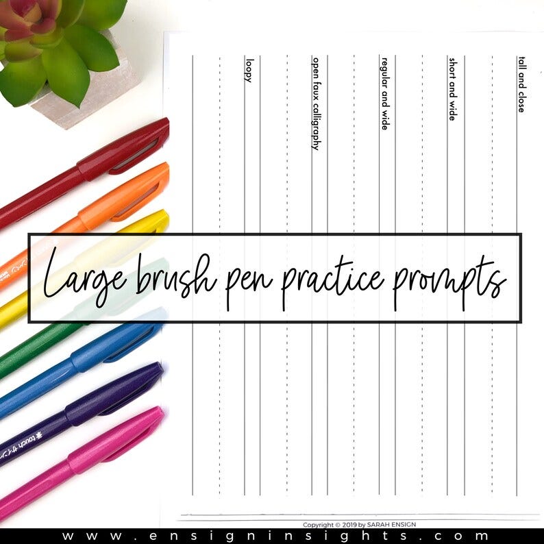 May include: A white sheet of paper with black lines and the text "Large brush pen practice prompts" printed in black.  There are seven different colored brush pens on the paper.