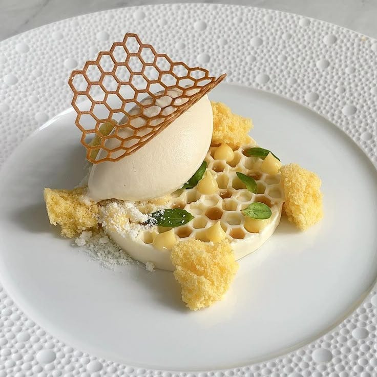 This may contain: a white plate topped with an ice cream dessert