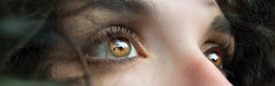 Image of woman with illuminated brown eyes looking upwards.