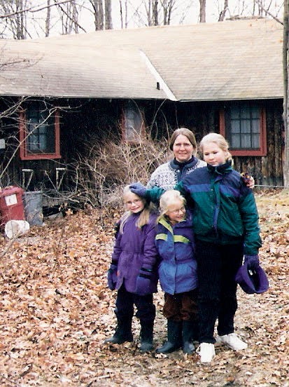 The author stands in front of an upstate NY cabin with her mother and sisters, circa 1997