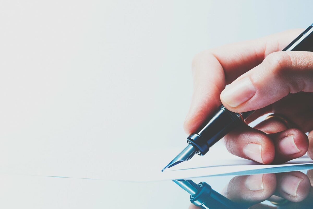 Hand writing goals with pen, Full Focus Planner, enhancing productivity and work-life balance through planning.