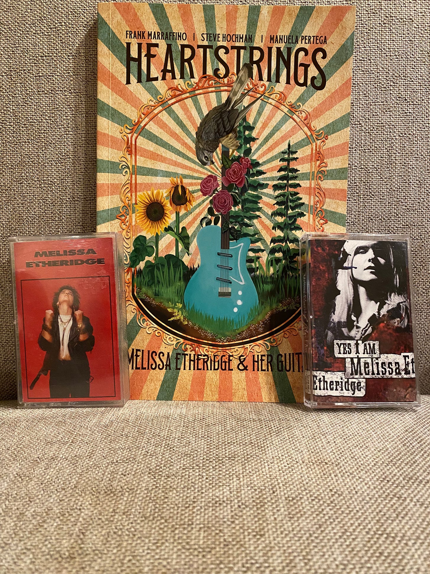 Photograph of Heartstrings: Melissa Etheridge and Her Guitars graphic novel with two cassette tapes of Melissa Etheridge's debut album and her album titled "Yes I Am."