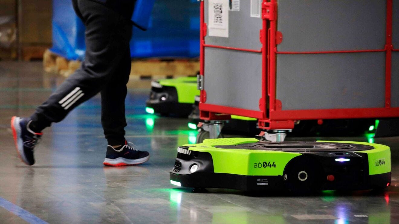 Protetus, an autonomous Amazon robot, moves bins of packages to the loading dock.