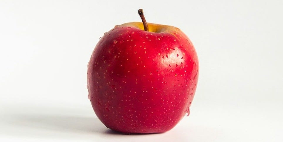 red apple on white surface red apple on white surface