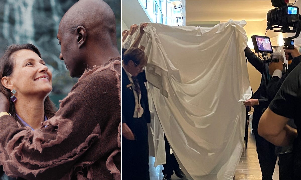 Smiling mixed race couple on the left, wedding guests holding up a sheet on the right