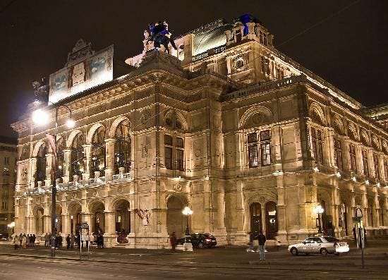 Vienna State Opera with many windows and a statue on top

Description automatically generated