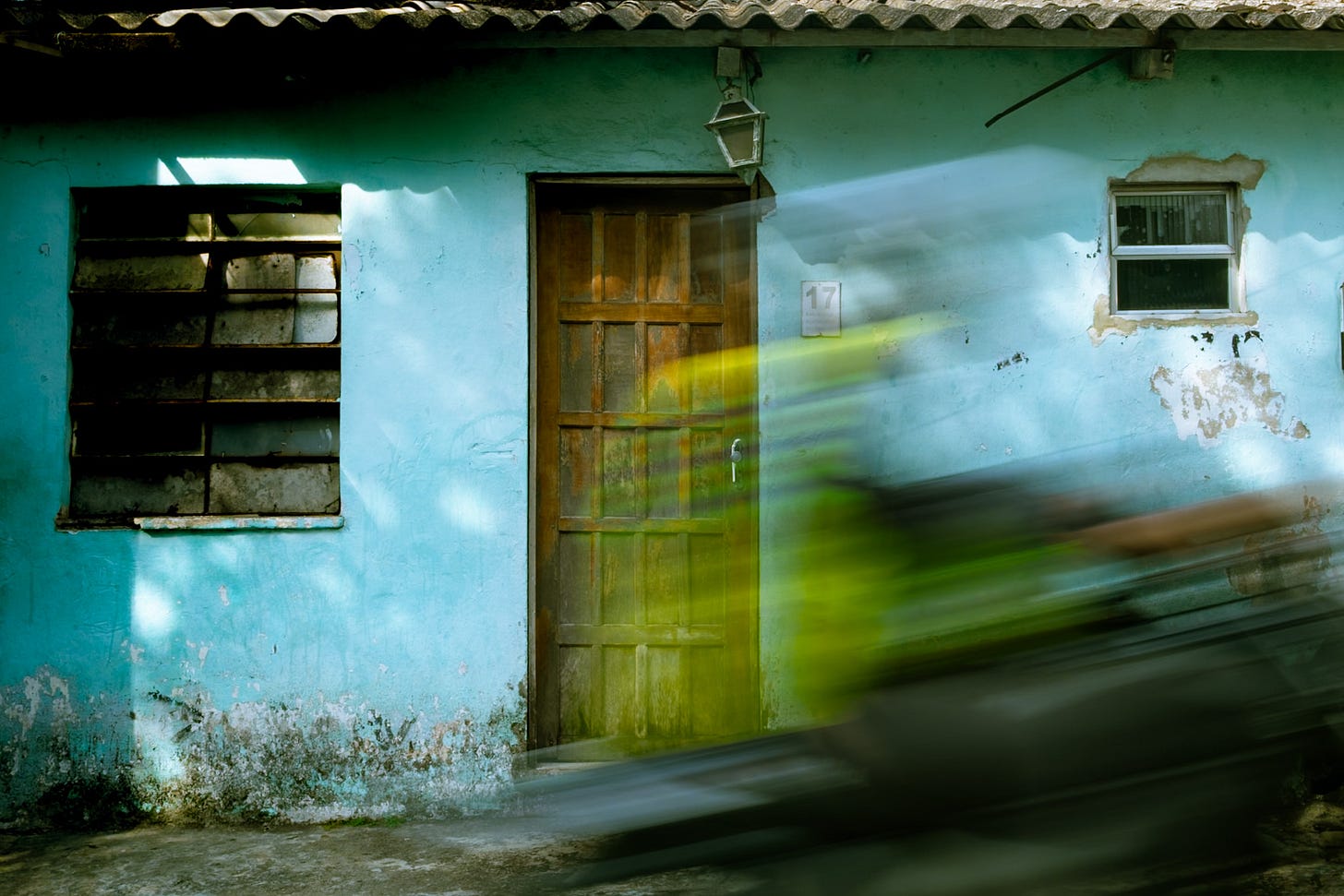 Blurred motorbike zapping in front of a house in the mainstream