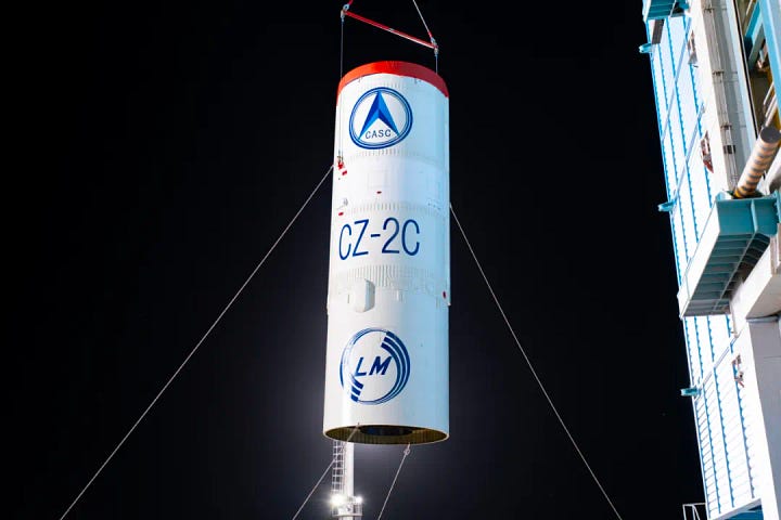 The first-stage, second-stage, and fairing for the Long March 2C launch vehicle heading to and being stacked ahead of the launch mission.