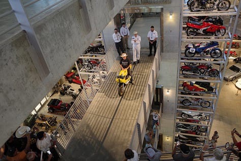Barber Vintage Motorsports Museum Sign; vintage motorcycles on display; Jessica with her hair in two braids in one of the areas of the bike museum;dozens of bikes stacked on a very tall display; King Kenny Roberts wearing a cowboy hat and sitting on a yellow bike