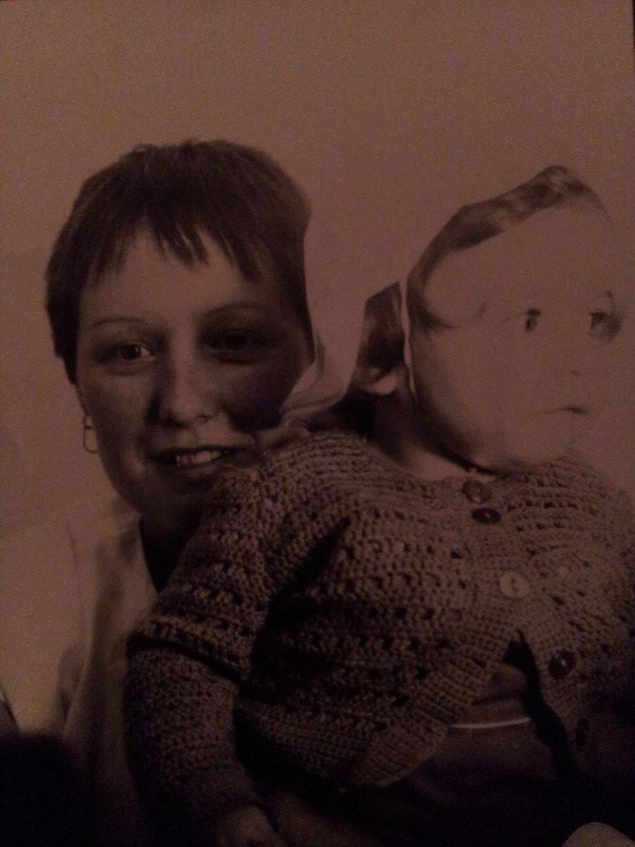 a black and white pic of a woman holding a child - the woman looks at the camera, the child is about 2 and looking off to the side. a black and white pic of a woman holding a child - the woman looks at the camera, the child is about 2 and looking off to the side.