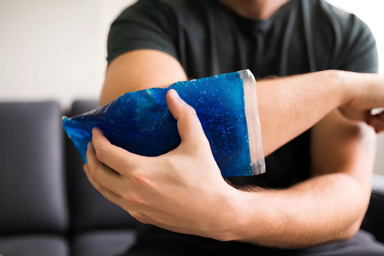 Close up of man holding an ice pack on his elbow.