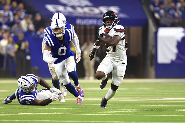 Woody Marks of the Houston Texans carries the ball past Germaine Pratt and Cam Bynum of the Indianapolis Colts during the second quarter at Lucas Oil...
