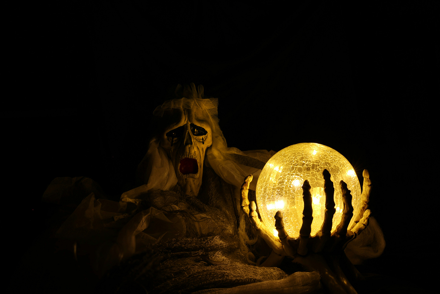 ghostly skeleton figure holding a glowing yellow orb