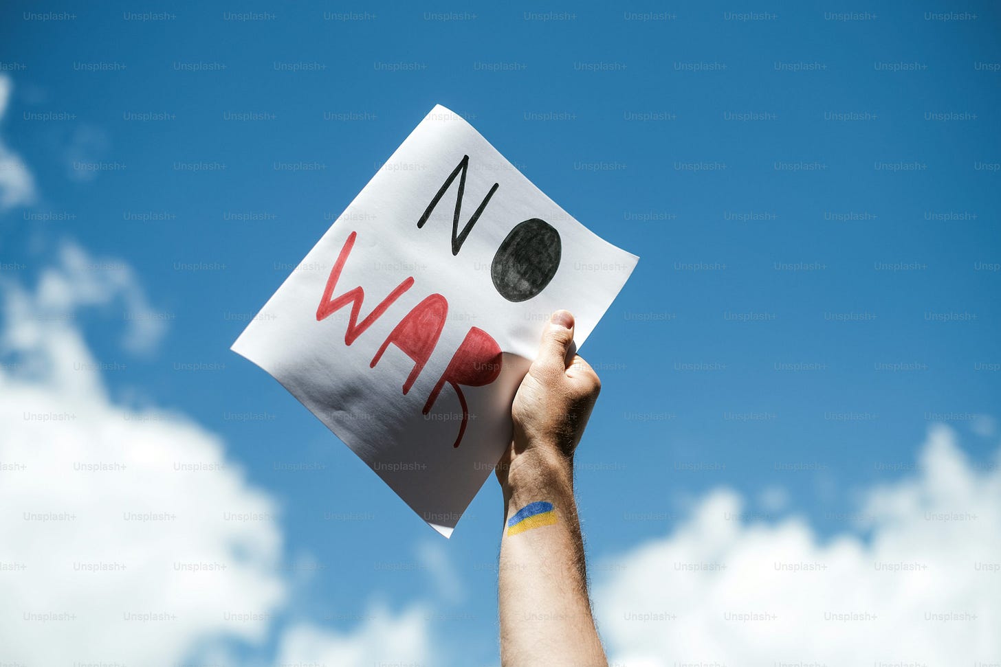 a person holding up a sign that says no war a person holding up a sign that says no war