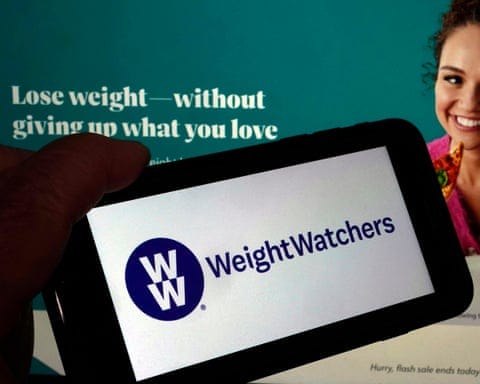 smartphone with the WeightWatchers logo on it, in front of ad saying 'lose weight – without giving up what you love'