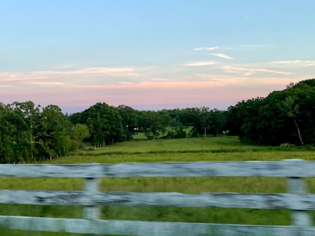 green farm pasture under blue sky at dusk
