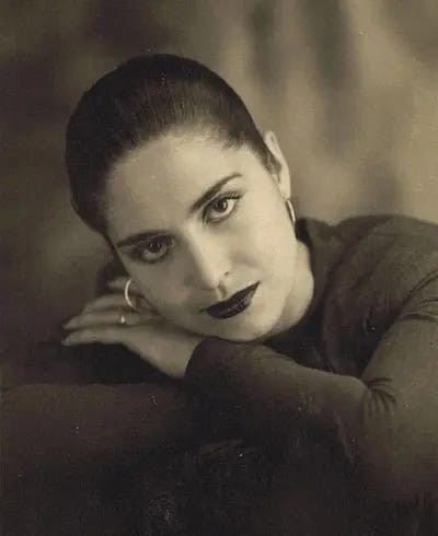 La fotografía es un retrato de la artista Pino Ojeda de joven con los brazos cruzados y su cabeza sobre ellos, como si estuviese acostada. La foto es en blanco y negro. 