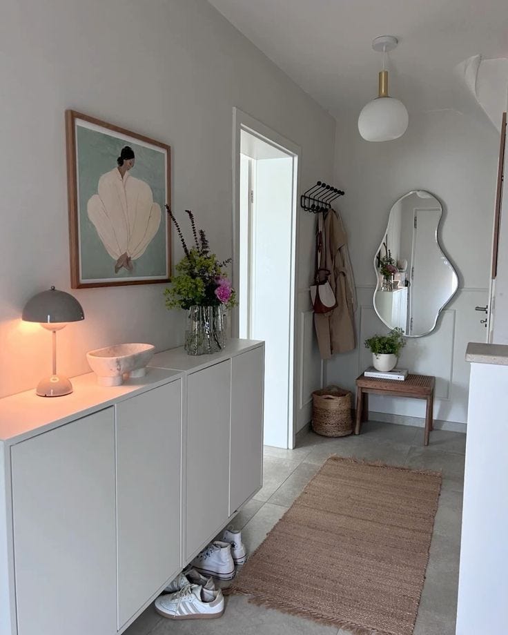 This may contain: a room with a rug, mirror and shoes on the floor in front of it