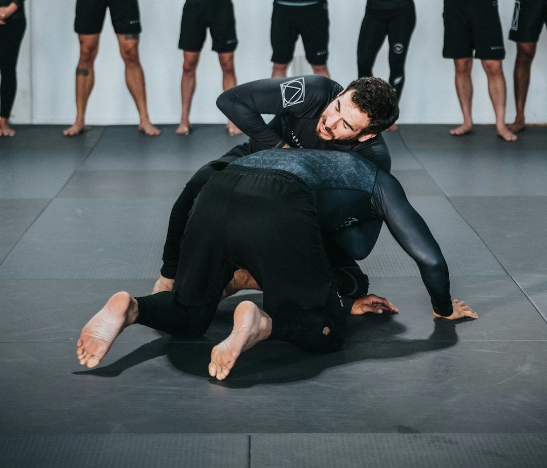 group of people in black shirts and black pants doing yoga