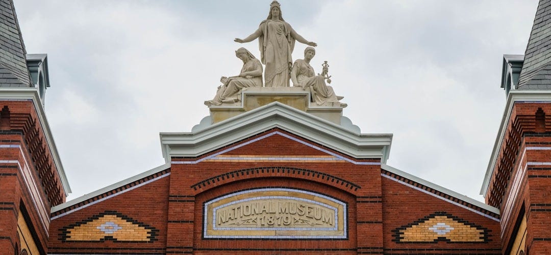 a building with a statue on top of it a building with a statue on top of it