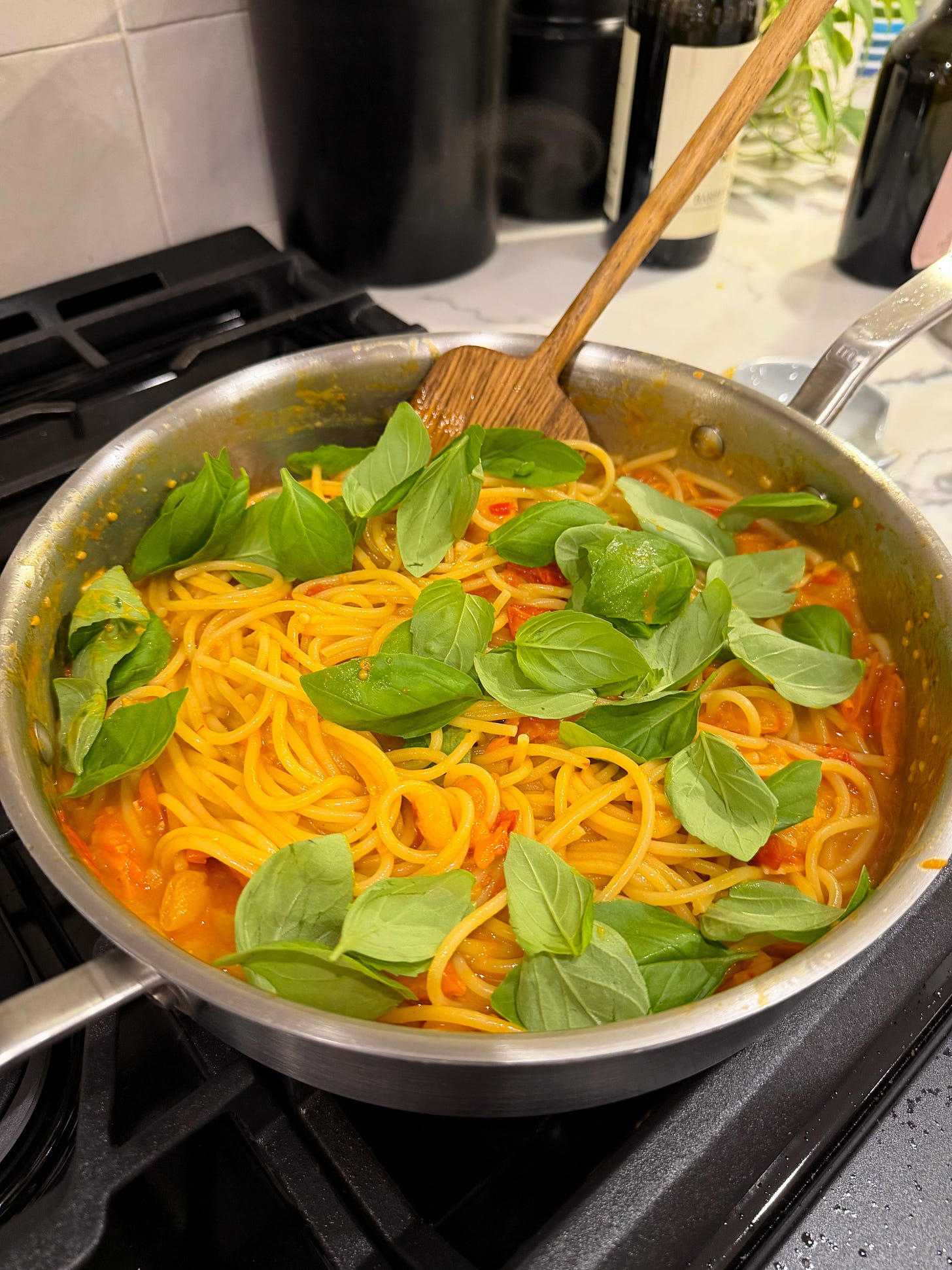 A Made In skillet with cherry tomato pasta and basil.