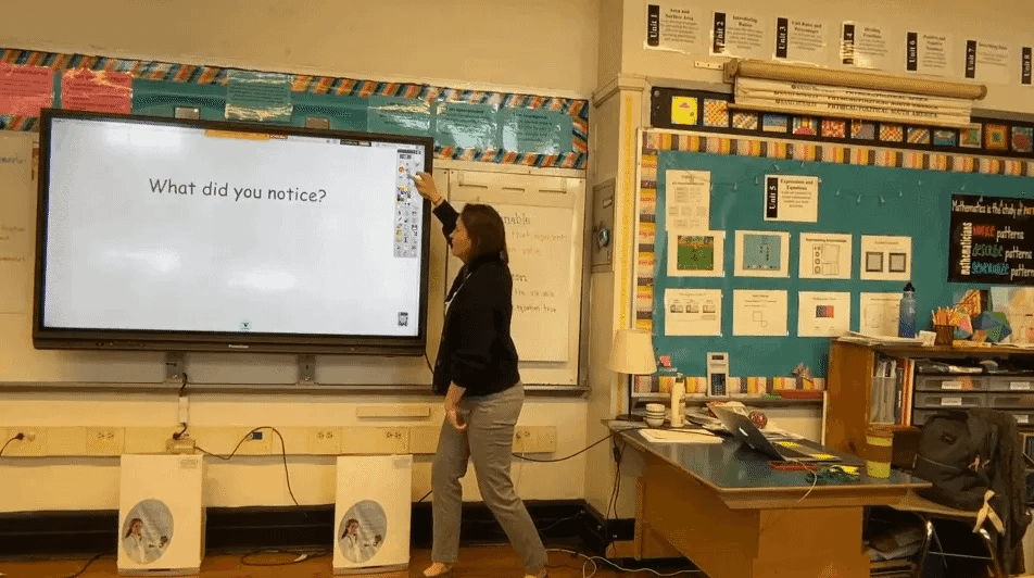 Liz Clark Garvey taps a button and "What do you notice?" on a whiteboard then changes to a picture of an array with filled in squares. It goes away quickly.