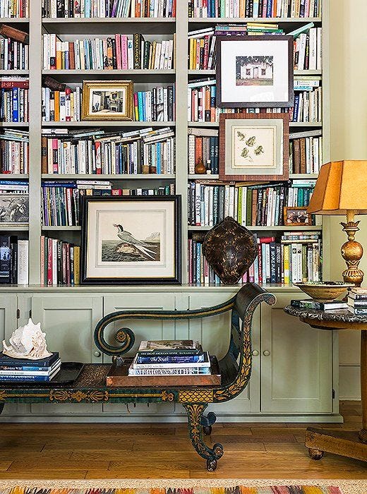 This may contain: the bookshelves are filled with many different types of books and there is a bench in front of them
