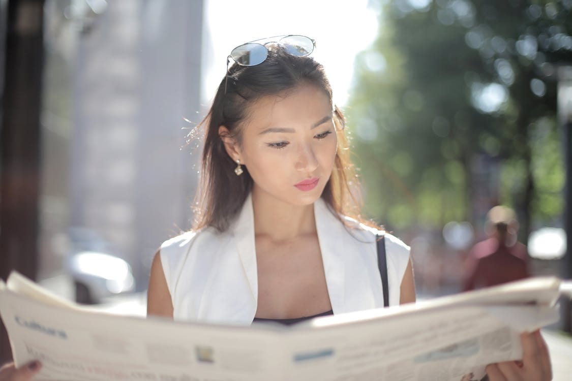 Woman Reading News Outdoors
