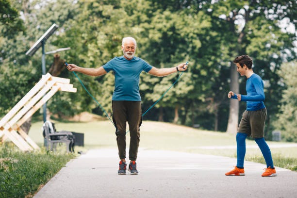 Working out, jumping rope. Beautiful spring day took out grandfather and his grandson outside. They decided to have active weekend, working out. senior man is jumping the rope, while his grandson is watching, counting jumps, cheering. a Child Full of Sunshine stock pictures, royalty-free photos & images