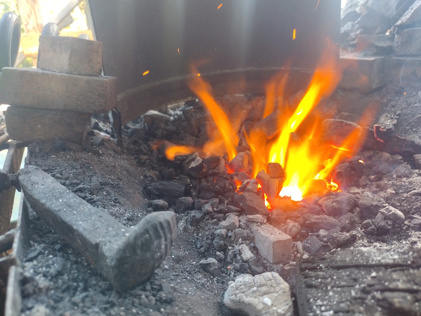 Fingers of fire jetting out from a coal bed as the blower blows.