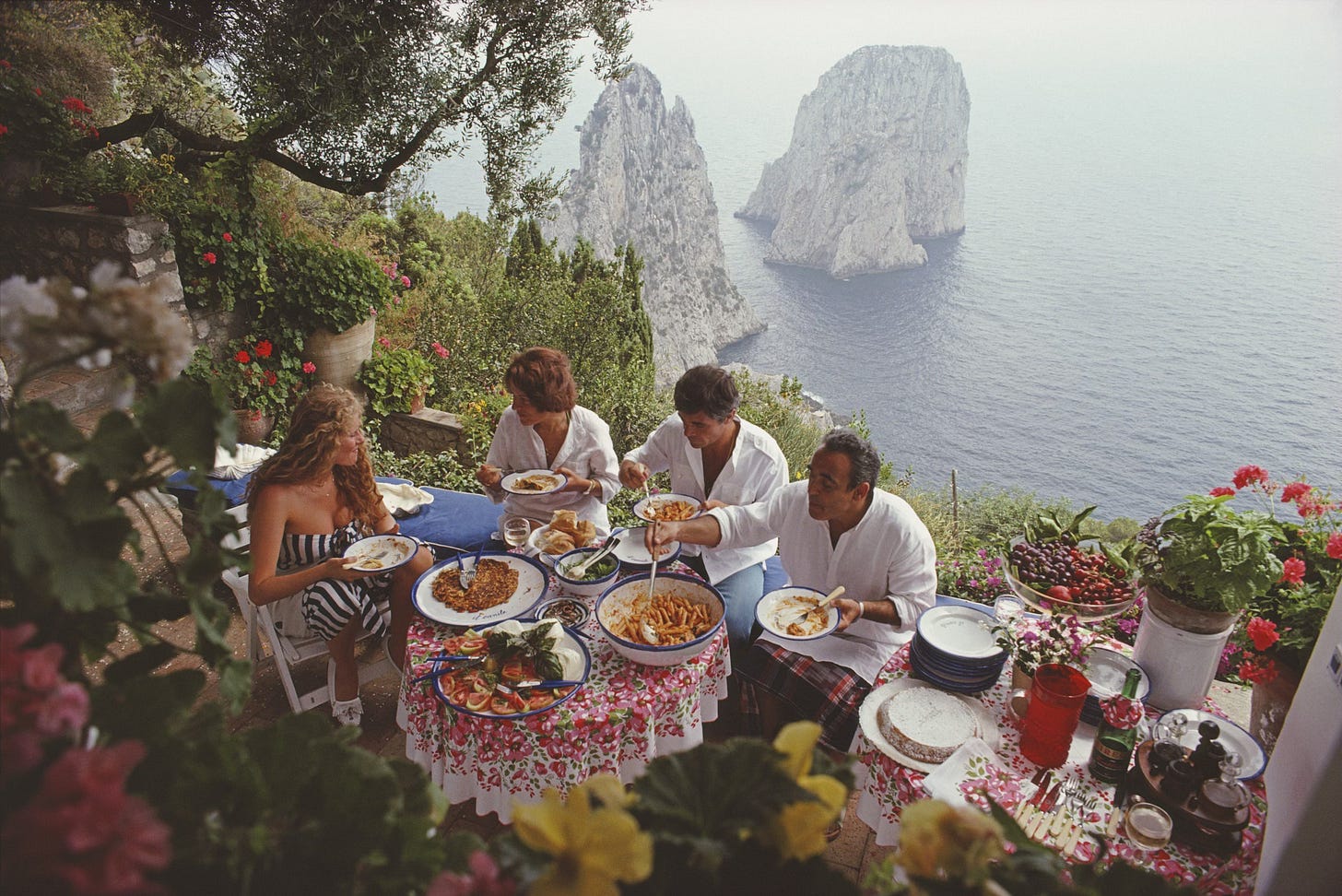 Domiziana Giordano and friends dining outdoors in Capri, 1980, photographed by Slim Aarons Domiziana Giordano and friends dining outdoors in Capri, 1980, photographed by Slim Aarons