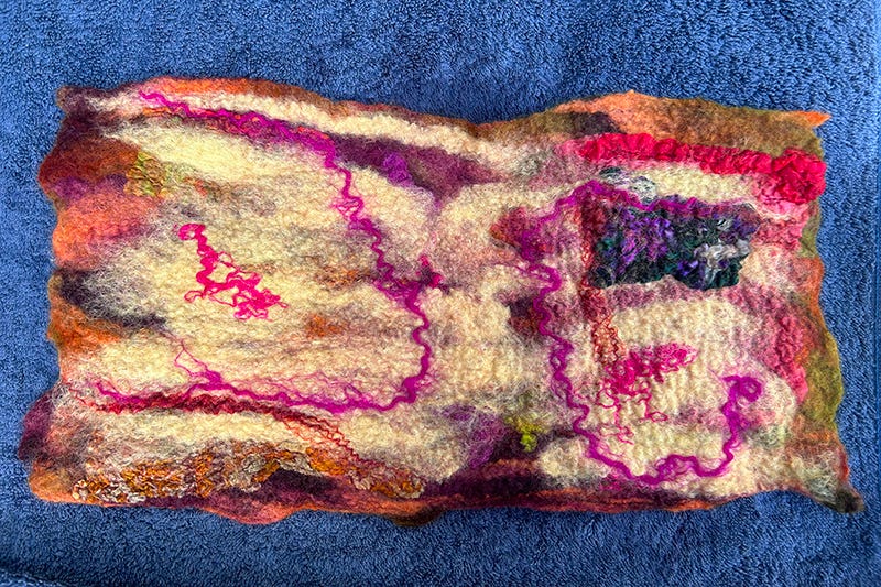 A piece of wool with many colours against a blue backdrop.