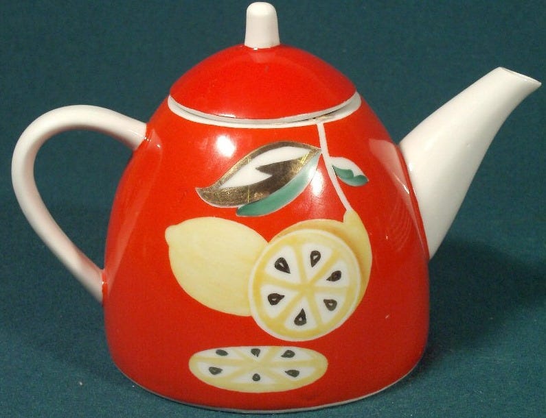 A Red teapot with a sliced lemon painted on it. A Red teapot with a sliced lemon painted on it.