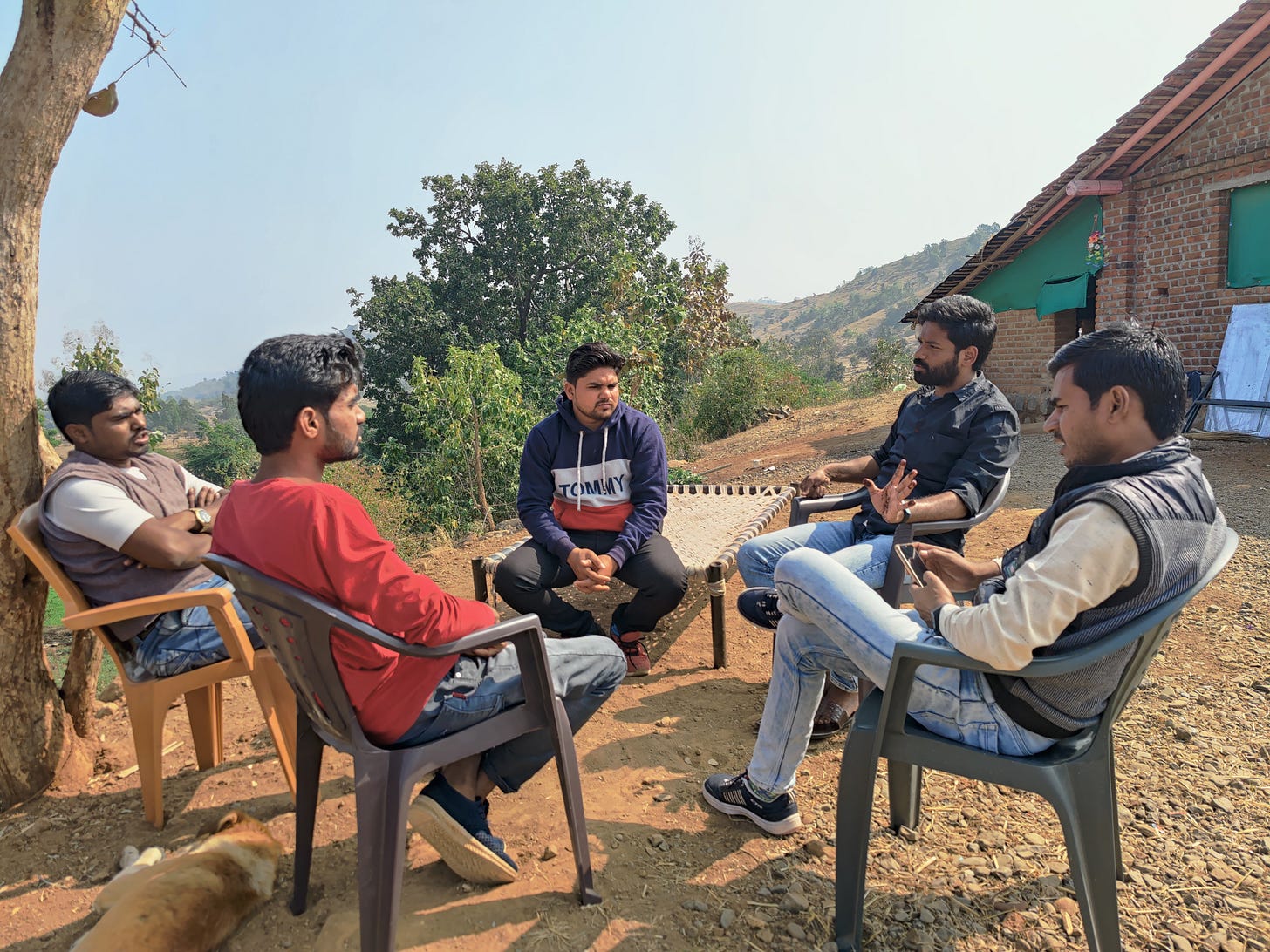 Five members of the Aadiwasi Janjagruti team having a conversation, sitting in a circle, discussing their issues