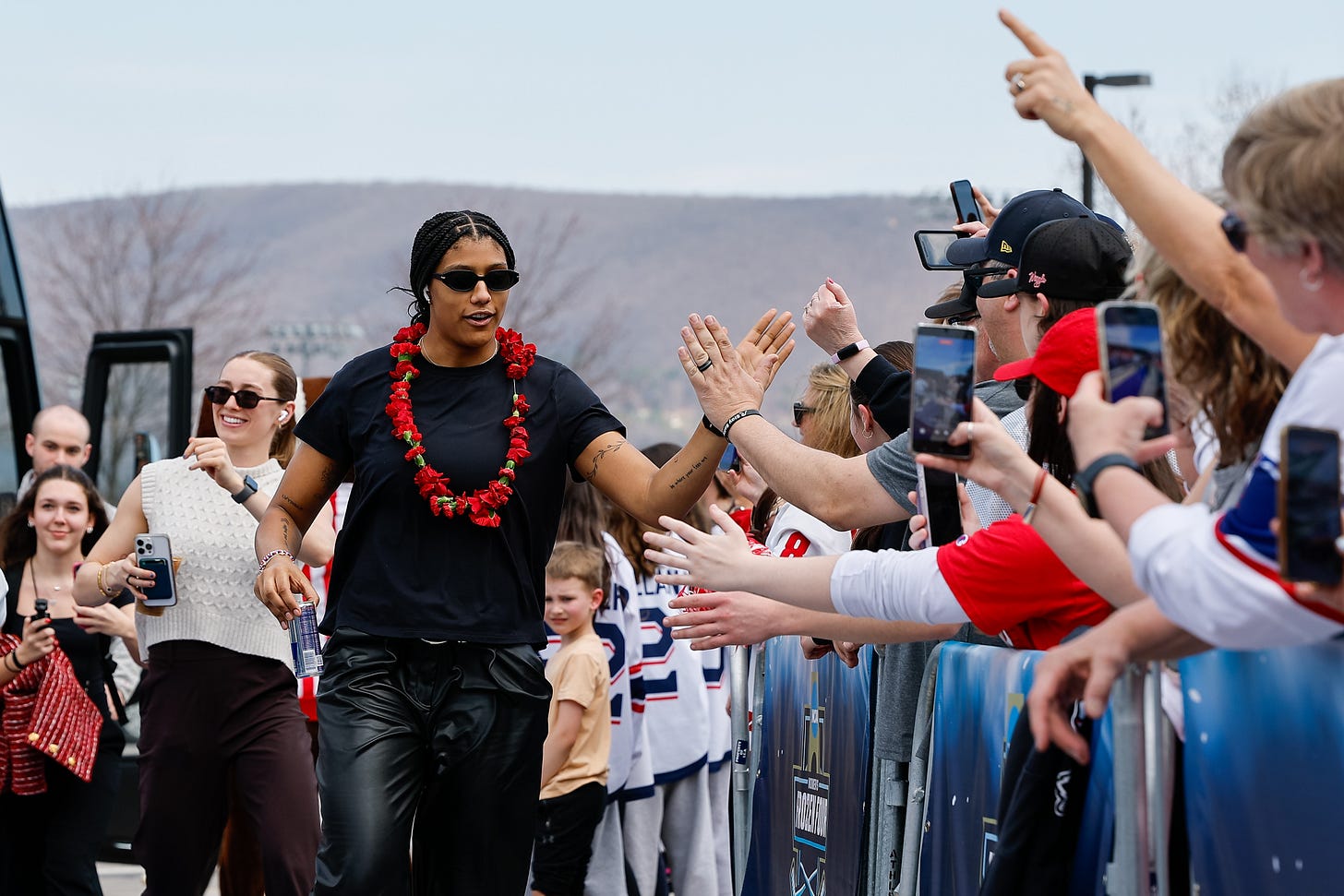 Laila Edwards high fives fans while Caroline Harvey walks in behind her