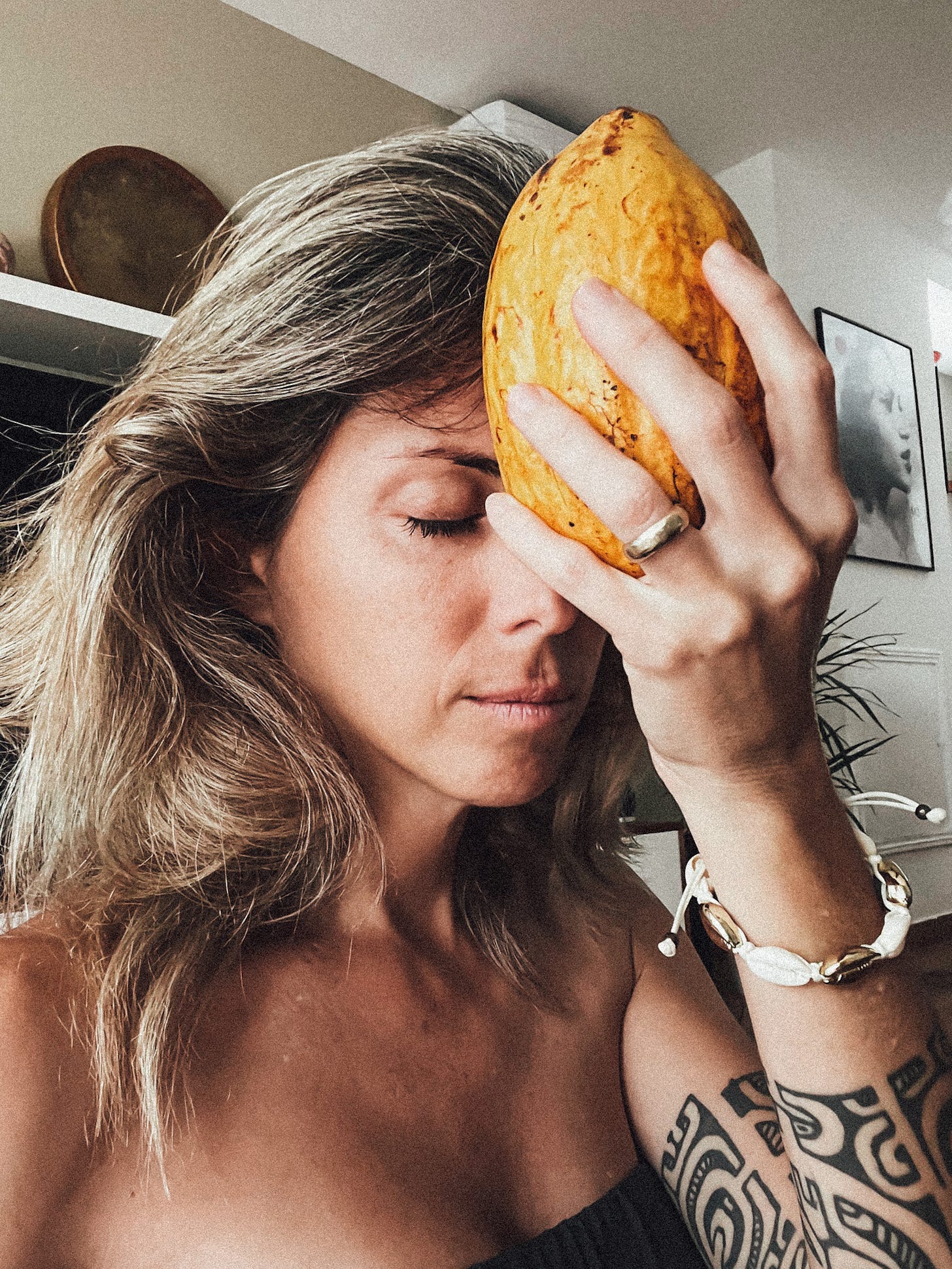 Femme en connexion avec le cacao saré via une cabosse posée sur son front